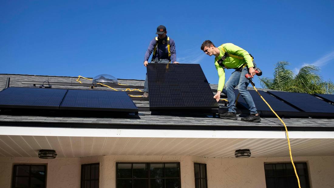 Two installers working together on a residential roof